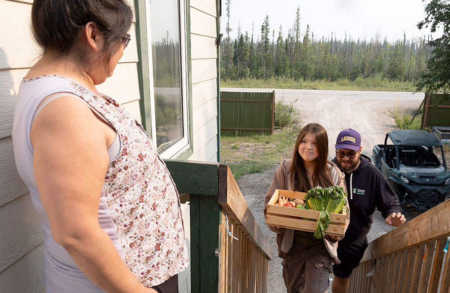 Young girl delivering a produce box to a neighbour