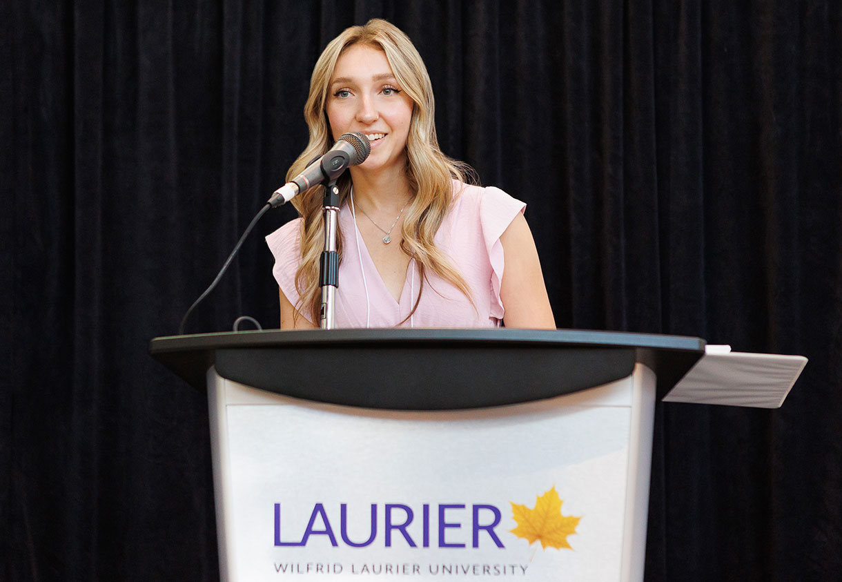 Mya Baxter stands at the podium during the 2024 Laurier Stedman Prize awards celebration