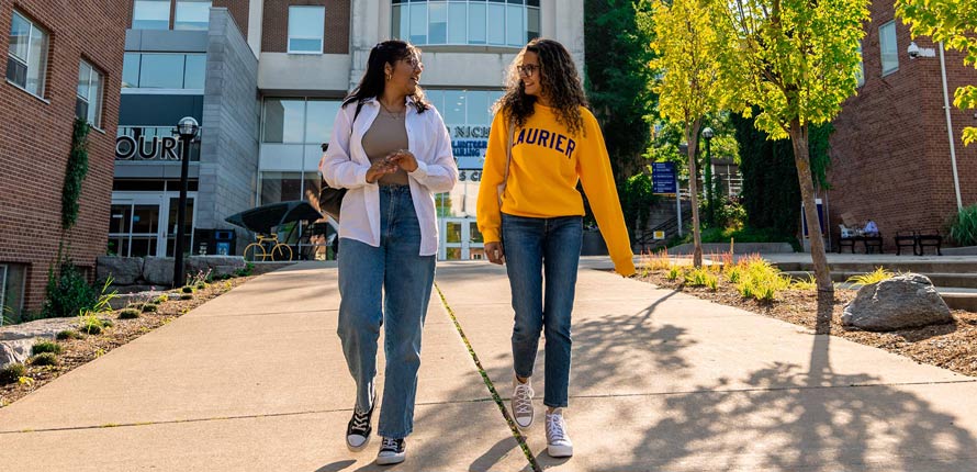 two female students walking on Waterloo campus in the summer