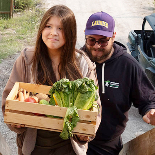 Two people delivering food from the community garden